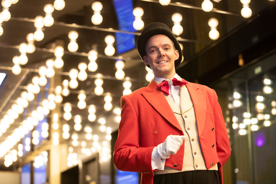 Uniformed cinema usher welcoming guests to a corporate film screening and private cinema event.