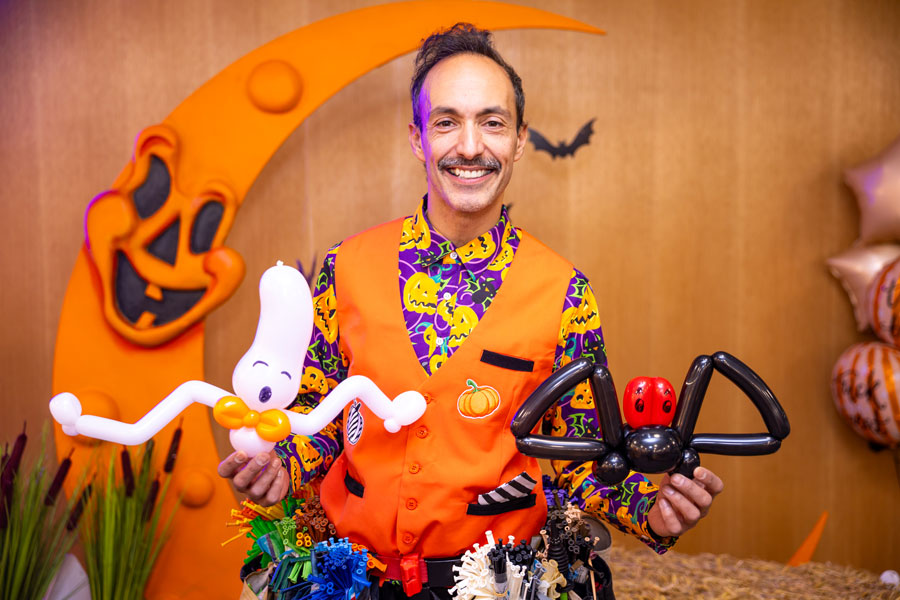 Professional balloon artist creating themed entertainment for guests at a corporate film screening event.